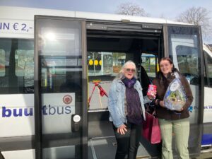 Bestuurslid Els den Os overhandigt de verrassing aan reiziger Demi Mulderij.